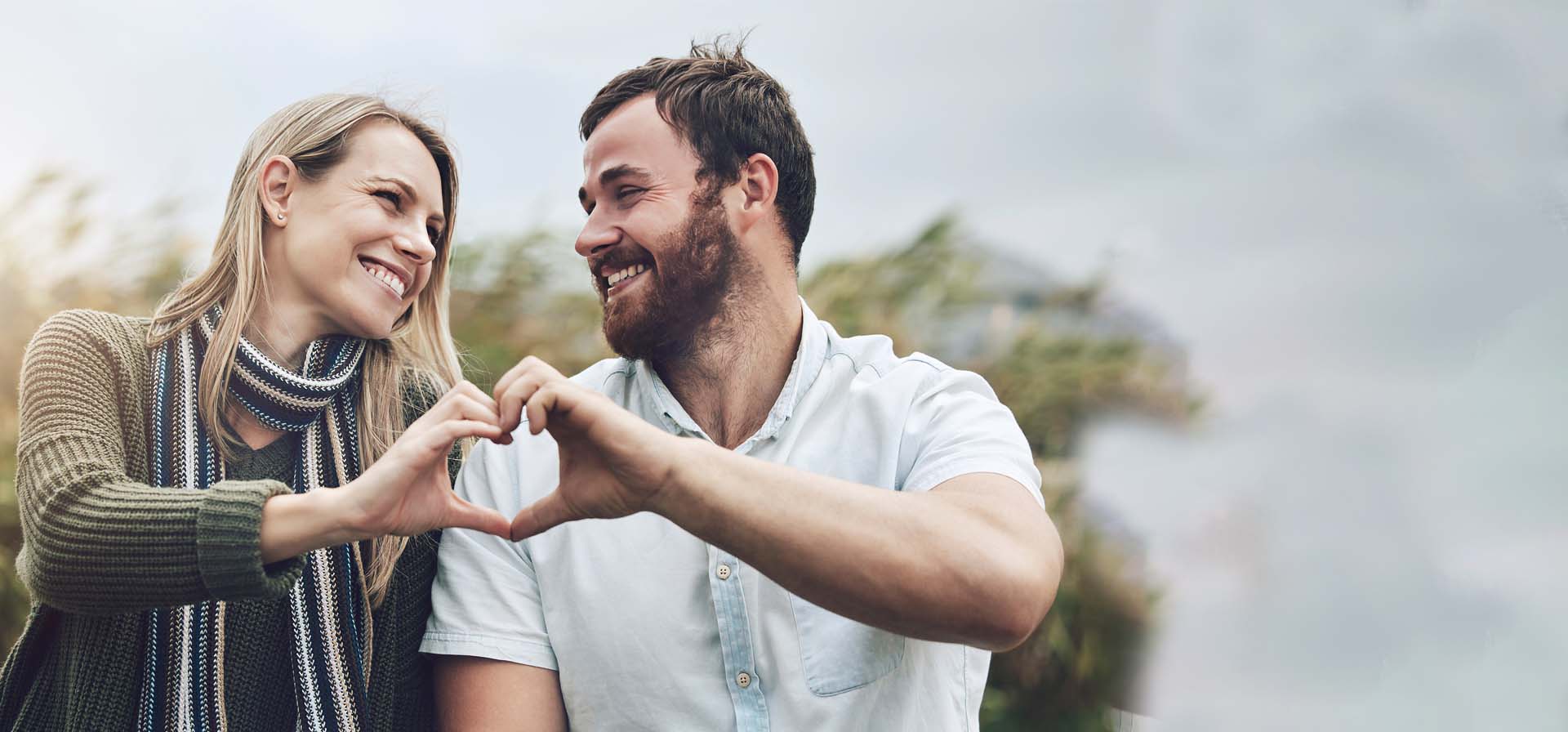 Un couple sourd formant un cœur avec leurs mains